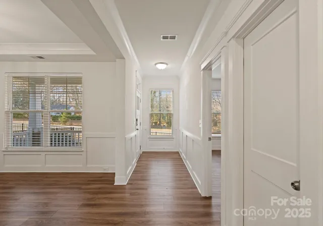 a view of a hallway with wooden floor and stairs