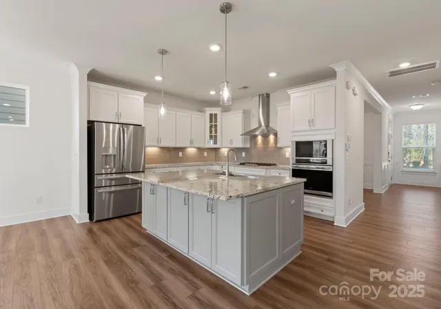 a kitchen with stainless steel appliances granite countertop a sink stove and refrigerator