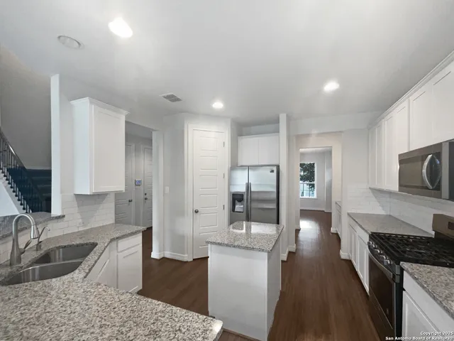 a kitchen with stainless steel appliances granite countertop a sink stove and refrigerator