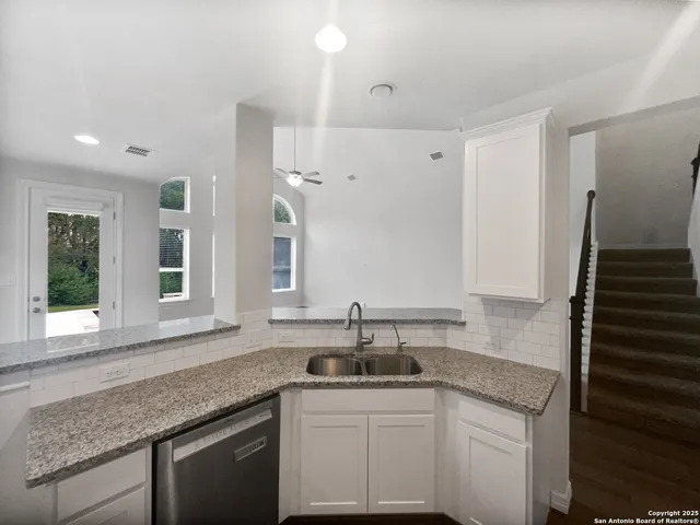 a kitchen with granite countertop a sink and cabinets