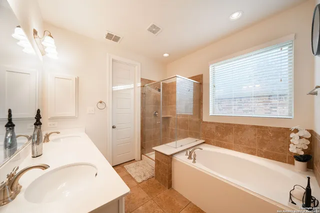 a bathroom with a tub sink and mirror