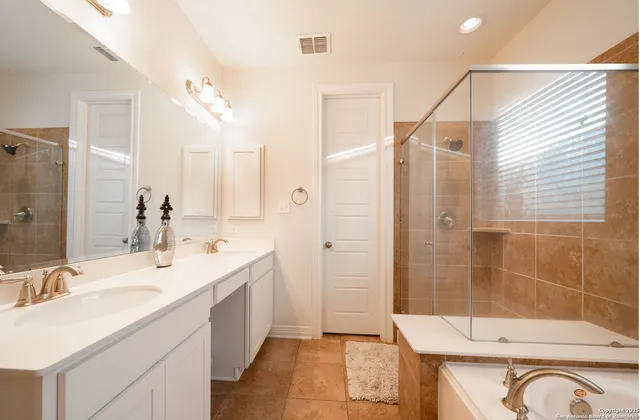 a bathroom with a double vanity sink mirror and shower
