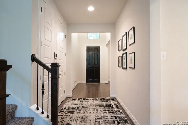 a view of a hallway with wooden floor and staircase