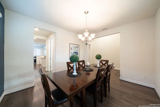 a dining room with furniture a chandelier and wooden floor