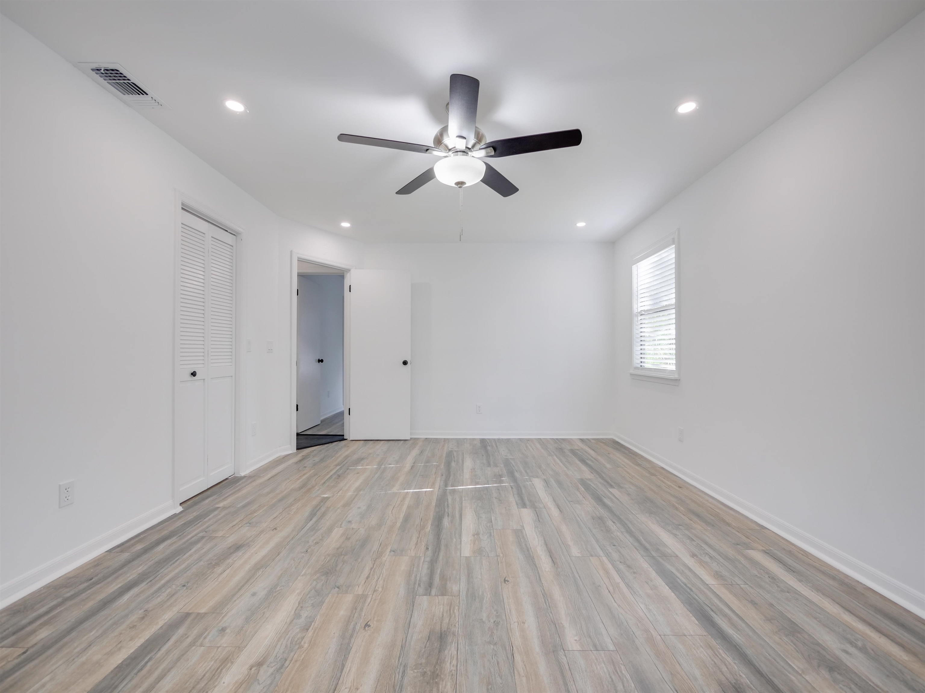 136 Bonita Road St. Augustine, FL 32086 - Photo 14 of 26 an empty room with wooden floor ceiling fan and windows