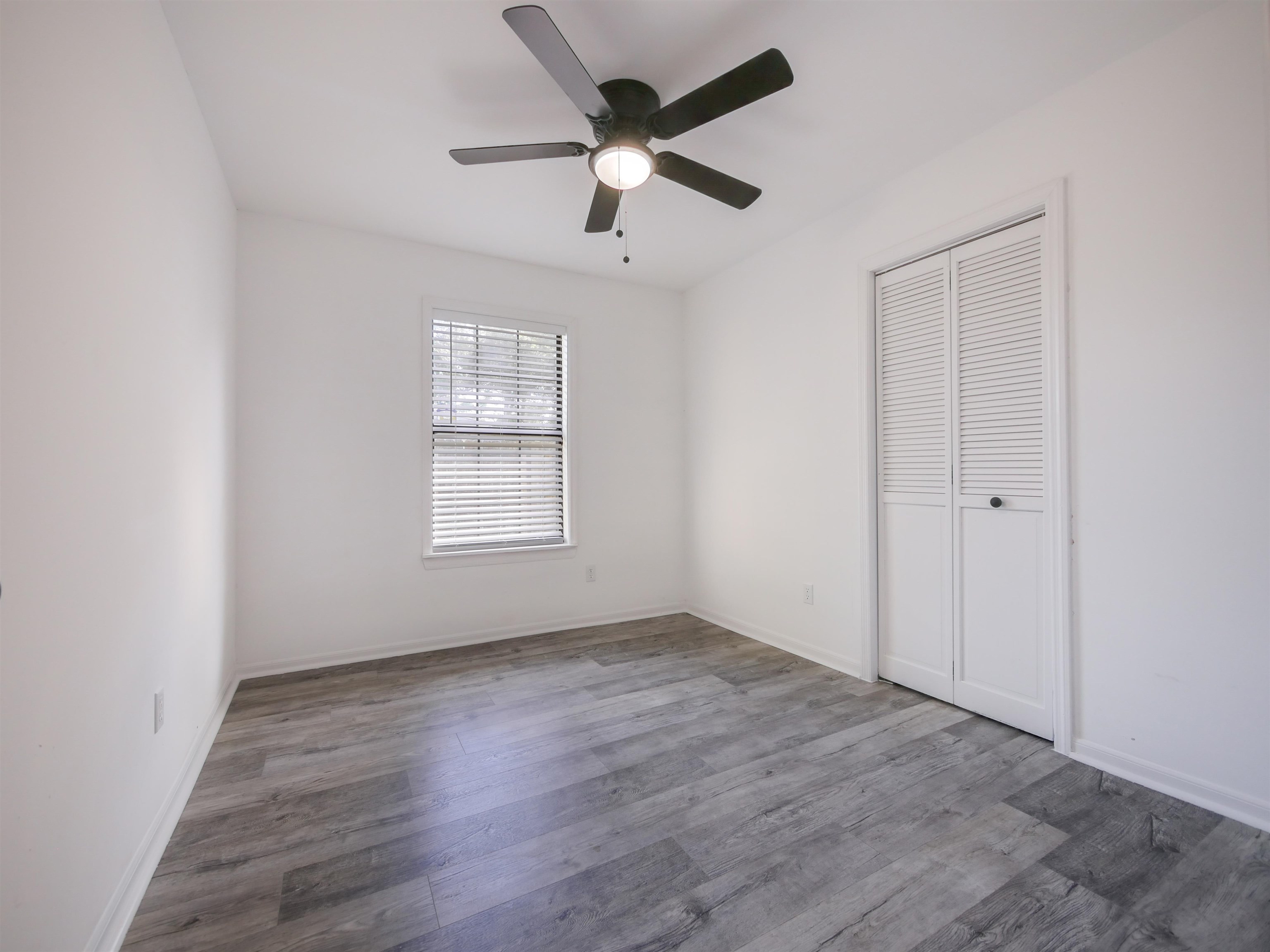 136 Bonita Road St. Augustine, FL 32086 - Photo 18 of 26 an empty room with wooden floor ceiling fan and windows