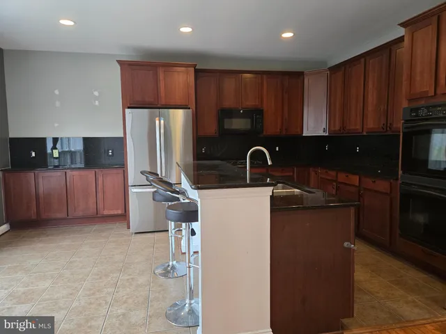 a kitchen with stainless steel appliances wooden cabinets a sink and a refrigerator