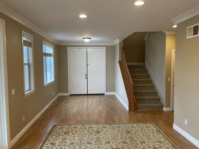 a view of hallway with stairs and wooden floor
