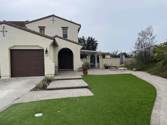 a front view of a house with a garden and yard