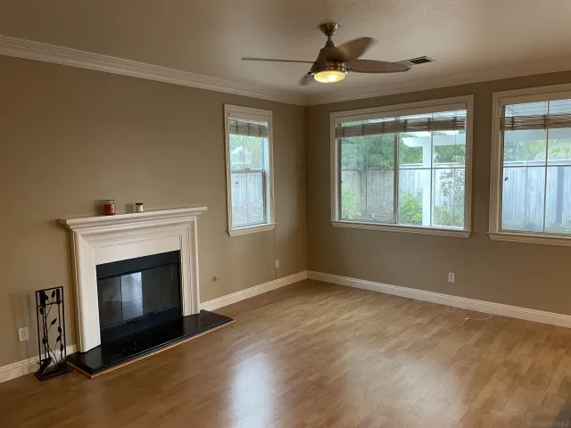 a view of an empty room with a fireplace and a window