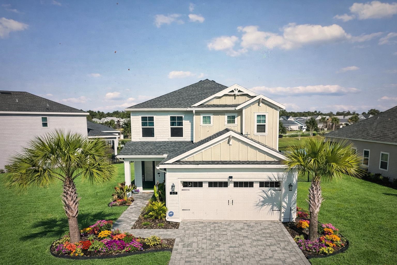 View of front of home with board and batten siding, a front lawn, decorative driveway, and roof with shingles