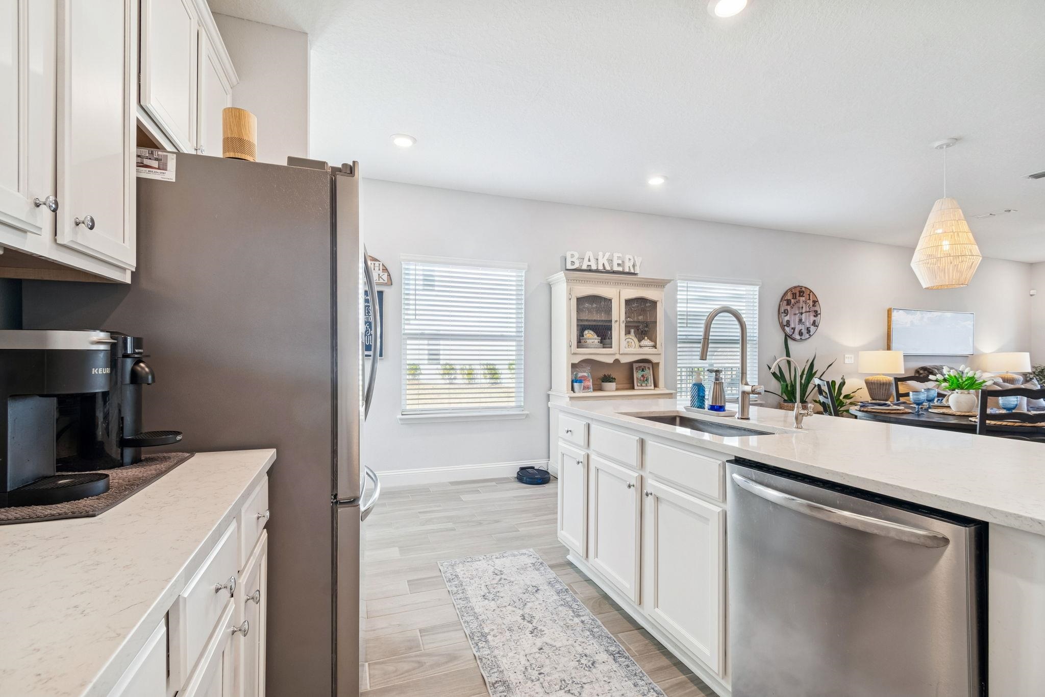 262 Killarney Avenue St. Johns, FL 32259 - Photo 11 of 100 Kitchen with white cabinetry, appliances with stainless steel finishes, decorative light fixtures, light wood-style flooring, and light stone counters