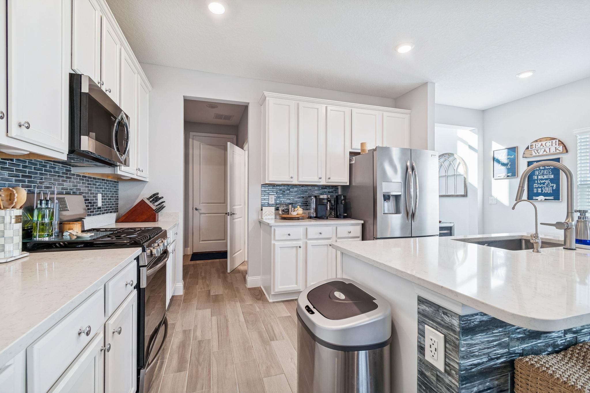 262 Killarney Avenue St. Johns, FL 32259 - Photo 14 of 100 Kitchen with appliances with stainless steel finishes, white cabinets, light stone counters, light wood finished floors, and recessed lighting