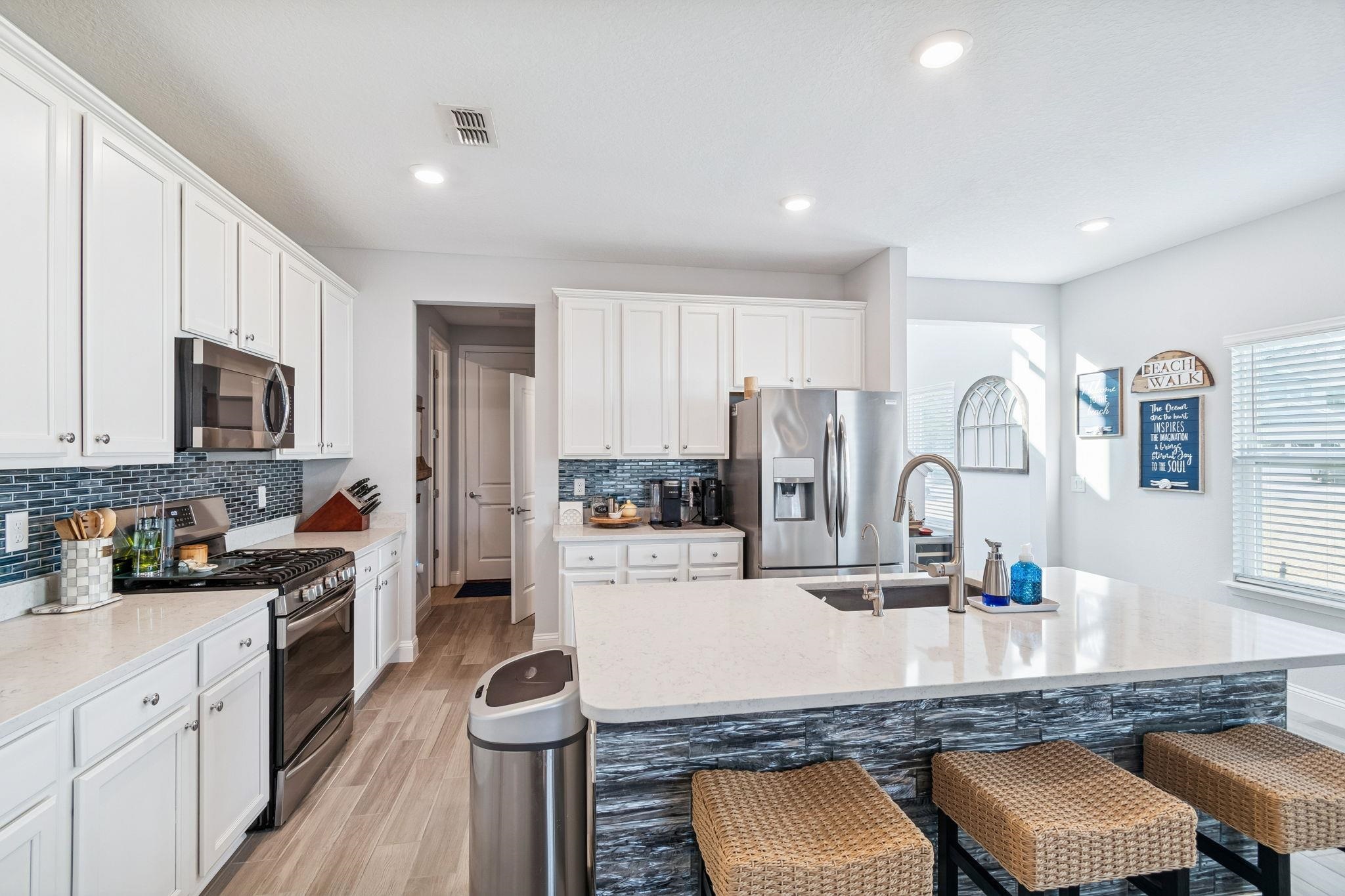 262 Killarney Avenue St. Johns, FL 32259 - Photo 15 of 100 Kitchen with a breakfast bar, white cabinets, a kitchen island with sink, stainless steel appliances, and recessed lighting