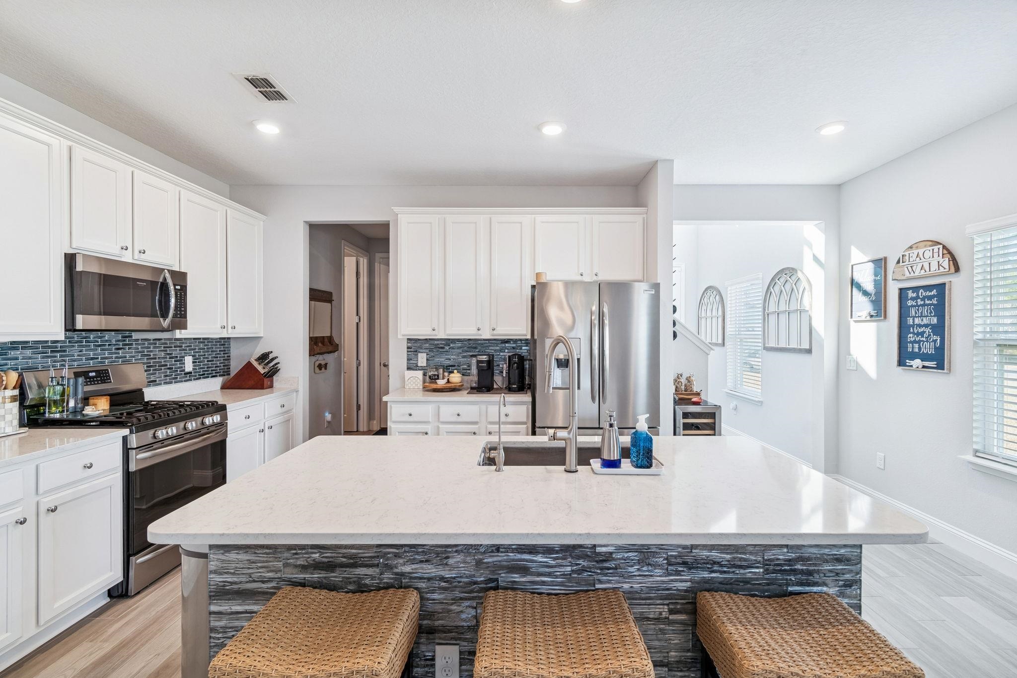 262 Killarney Avenue St. Johns, FL 32259 - Photo 16 of 100 Kitchen featuring appliances with stainless steel finishes, a breakfast bar, light wood-style flooring, white cabinets, and recessed lighting