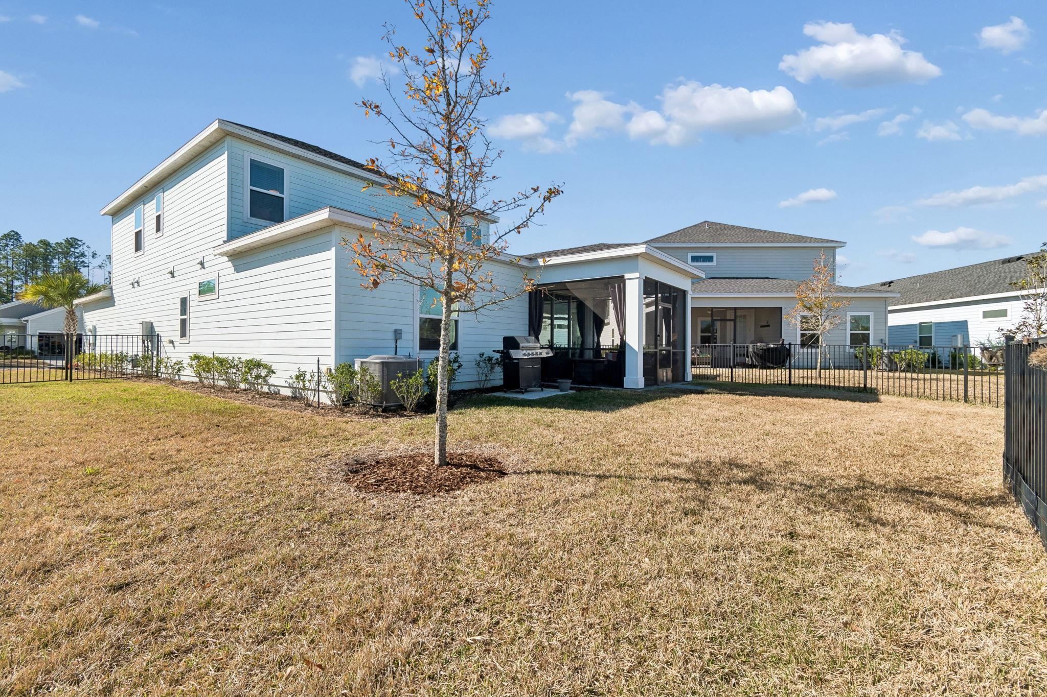 262 Killarney Avenue St. Johns, FL 32259 - Photo 67 of 100 Back of house with a fenced backyard, a sunroom, and a patio