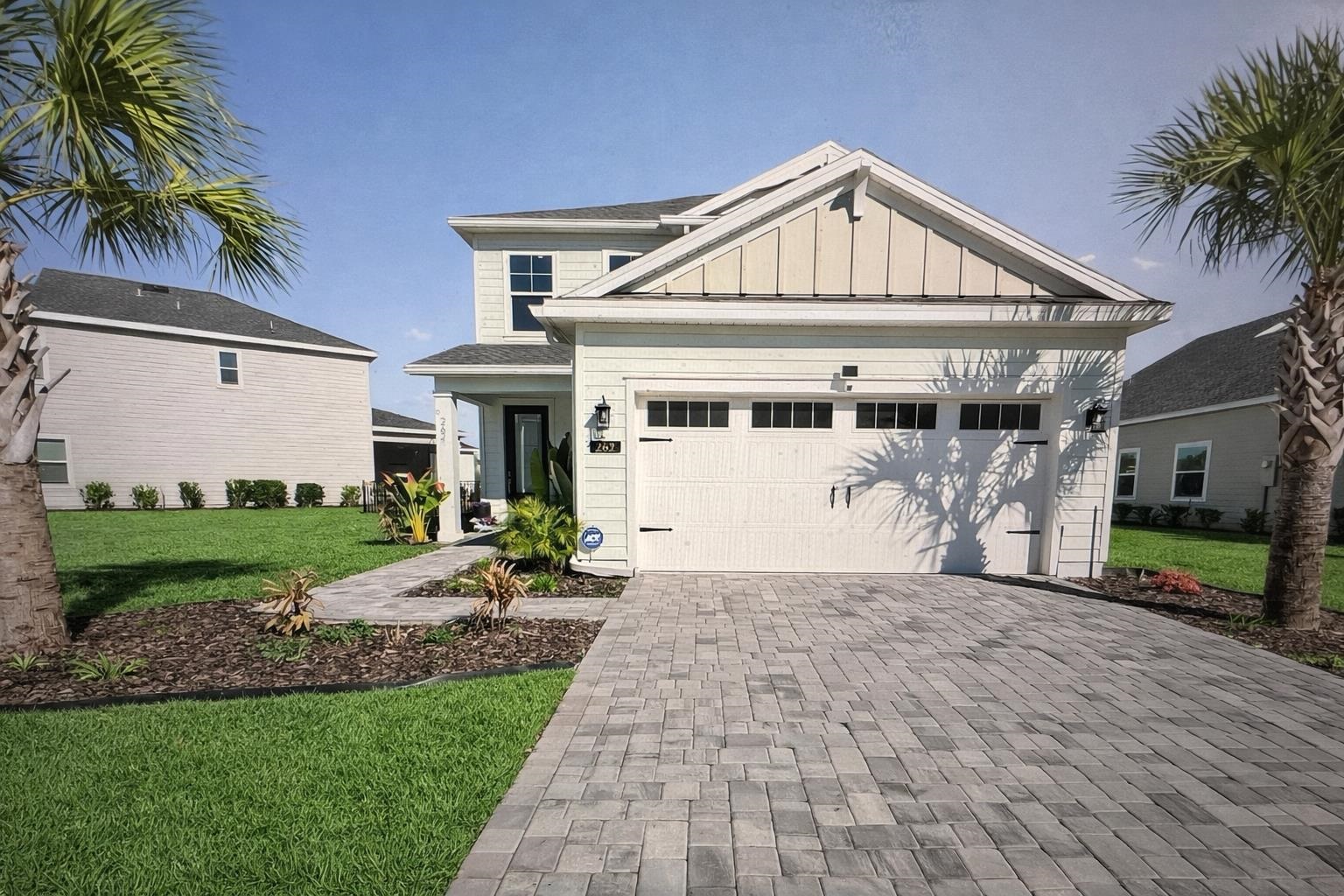262 Killarney Avenue St. Johns, FL 32259 - Photo 71 of 100 View of front facade featuring board and batten siding, a front lawn, decorative driveway, and an attached garage