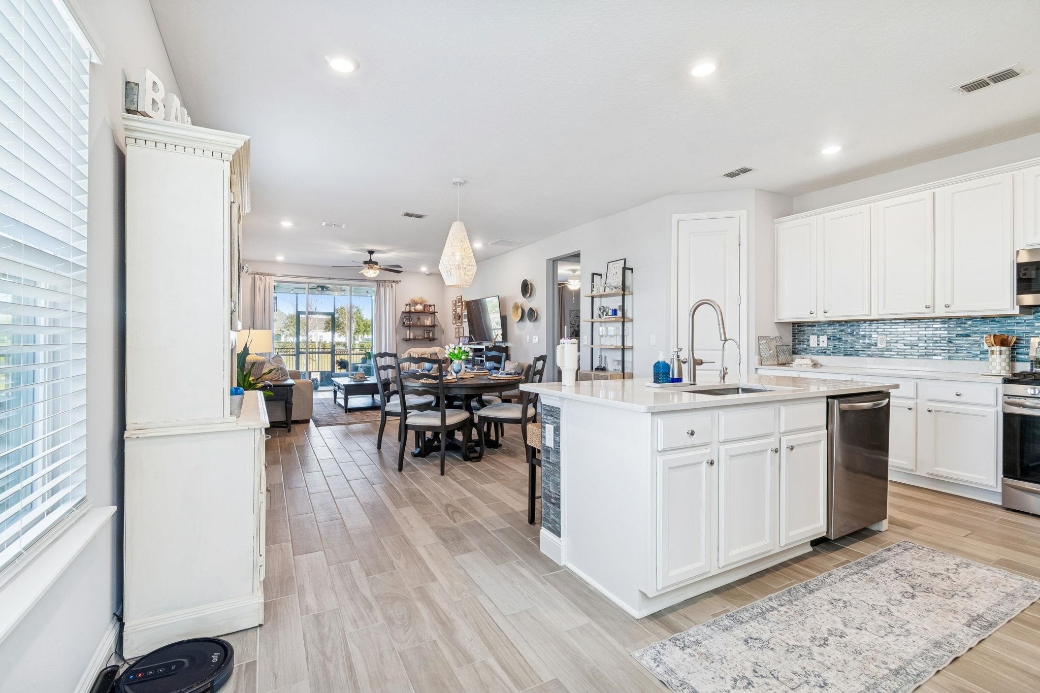262 Killarney Avenue St. Johns, FL 32259 - Photo 98 of 100 Kitchen with open floor plan, wood finish floors, white cabinets, a center island with sink, and recessed lighting