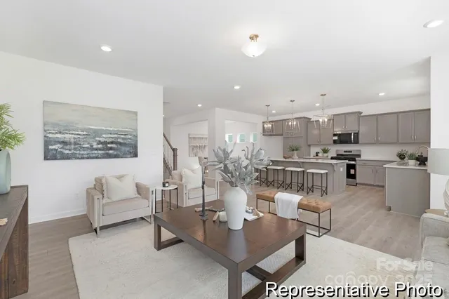 a living room with furniture and a view of kitchen