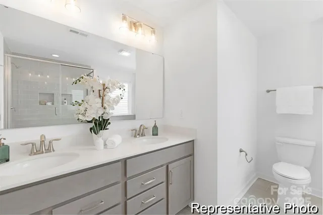 a bathroom with a granite countertop sink a toilet and a mirror