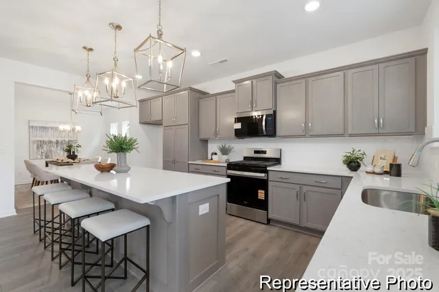 a kitchen with kitchen island granite countertop a sink cabinets and wooden floor