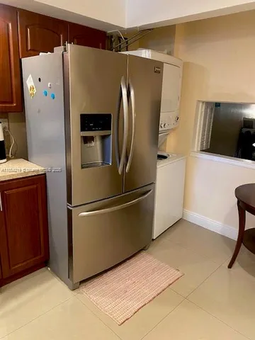 a metallic refrigerator freezer sitting in a kitchen