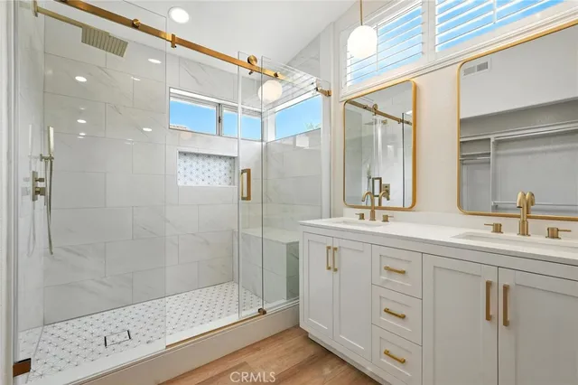 a bathroom with a double vanity sink mirror and shower