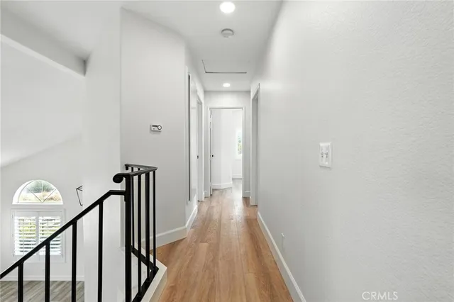 a view of a hallway with wooden floor and staircase