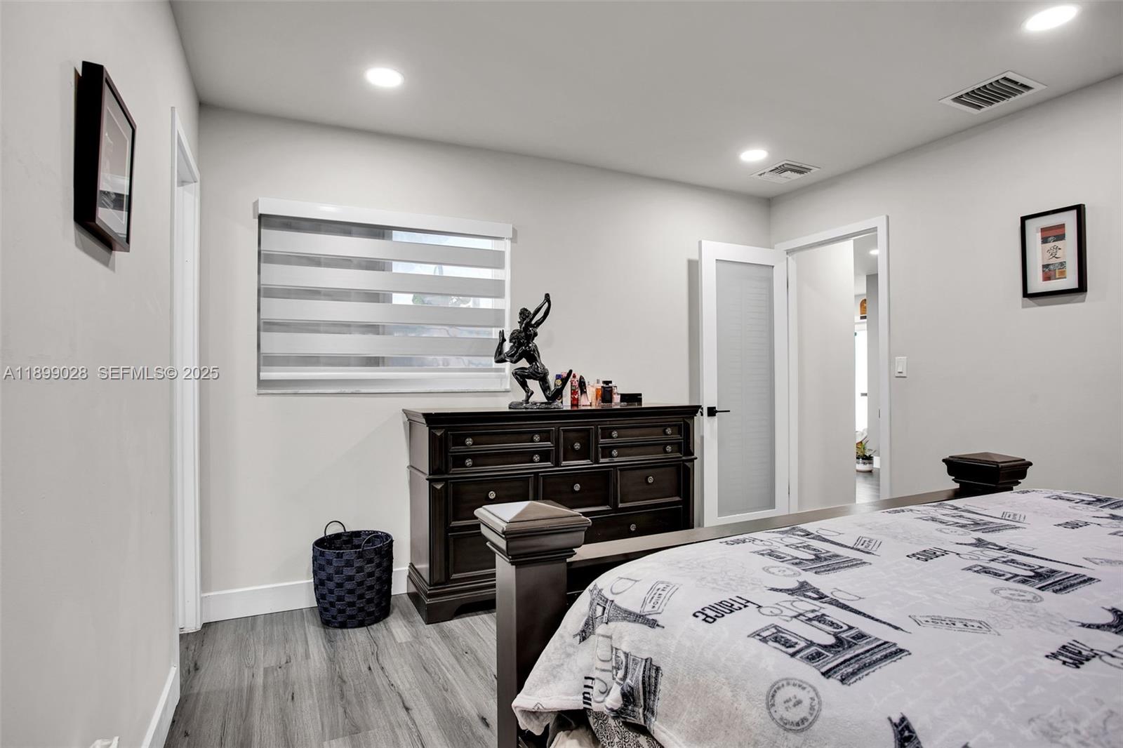 16922 Southwest 107th Place Miami, FL 33157 - Photo 28 of 45 a bedroom with a bed and wooden floor