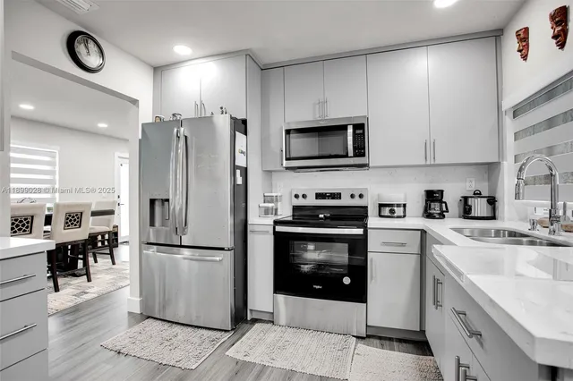 a kitchen with a sink cabinets and wooden floor