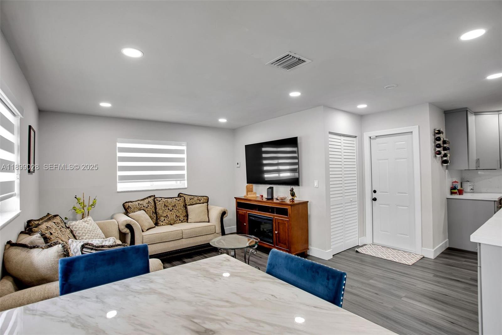 16922 Southwest 107th Place Miami, FL 33157 - Photo 42 of 45 a living room with furniture a wooden floor and a fireplace