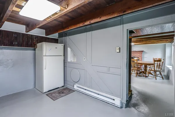 a view of an empty room with wooden floor fireplace and a window