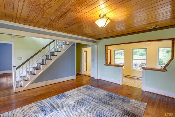 a view of an empty room with wooden floor and a fireplace