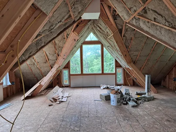 an empty room with wooden floor and a ceiling fan