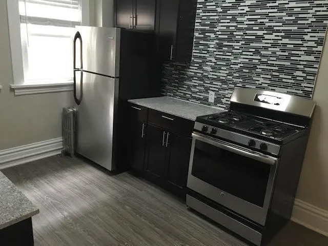 a kitchen with granite countertop a stove and a refrigerator