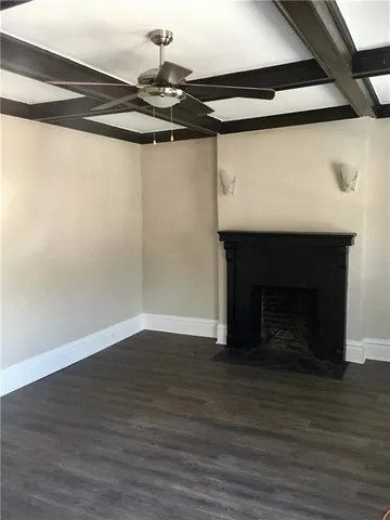 a view of a livingroom with wooden floor and a fireplace