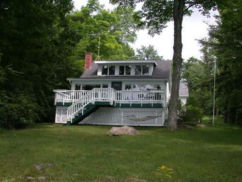 897 Algerie Road Otis, MA 01029 - Photo 1 of 2 a view of a house with a yard deck and a small cabin