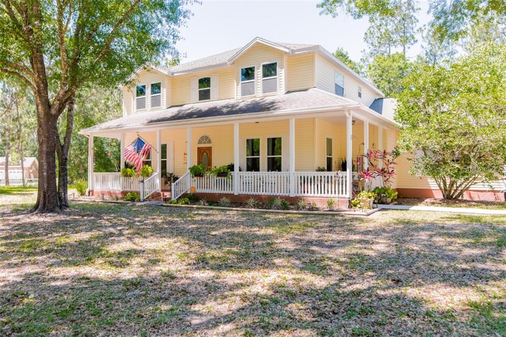 27619 Arlington Road Wesley Chapel, FL 33544 - Photo 1 of 1 Front of home with inviting wrap around porch