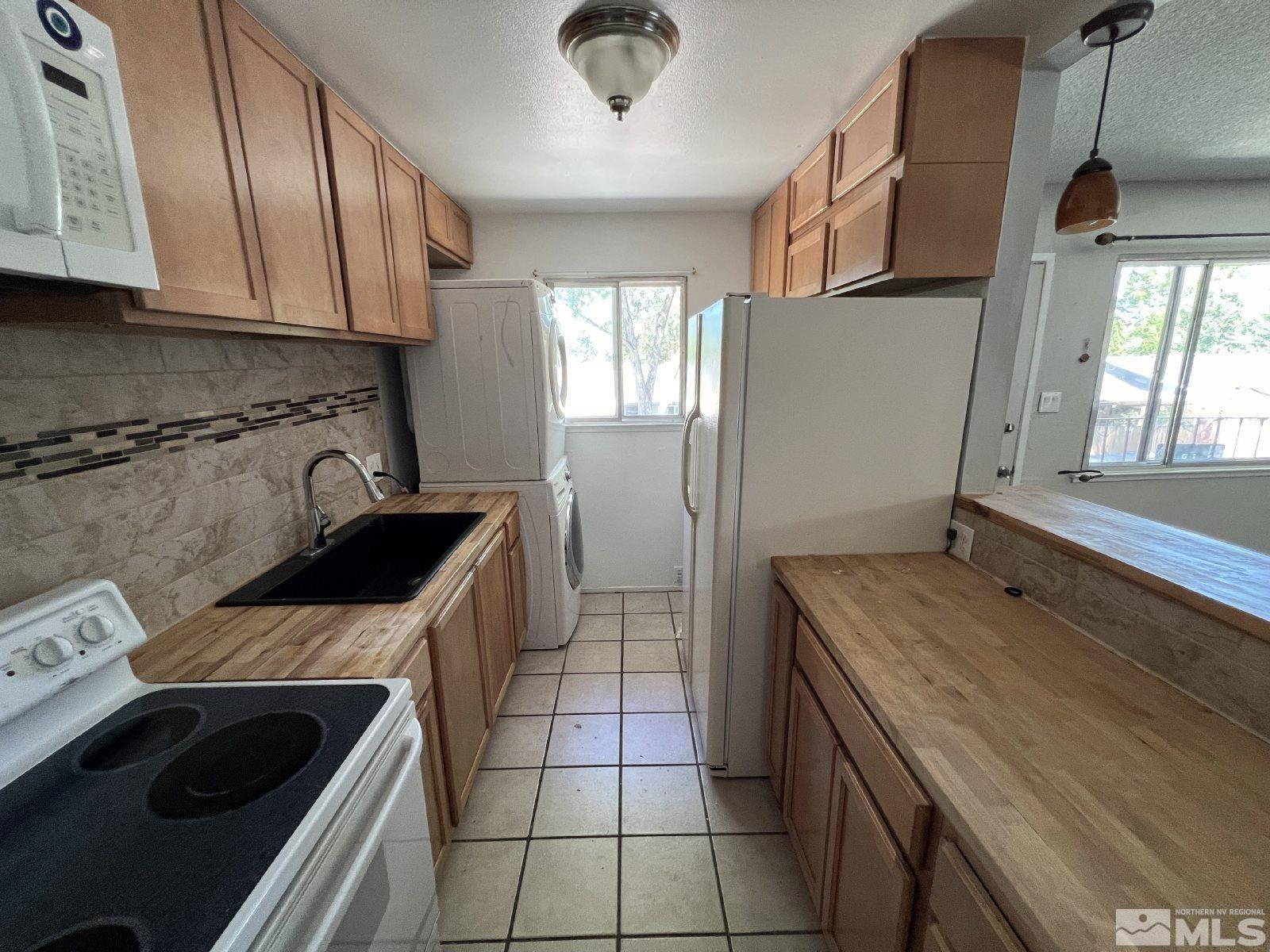 613 Pine Meadows Drive, Unit 4 Sparks, NV 89431 - Photo 2 of 14 a kitchen with a stove a sink and a refrigerator