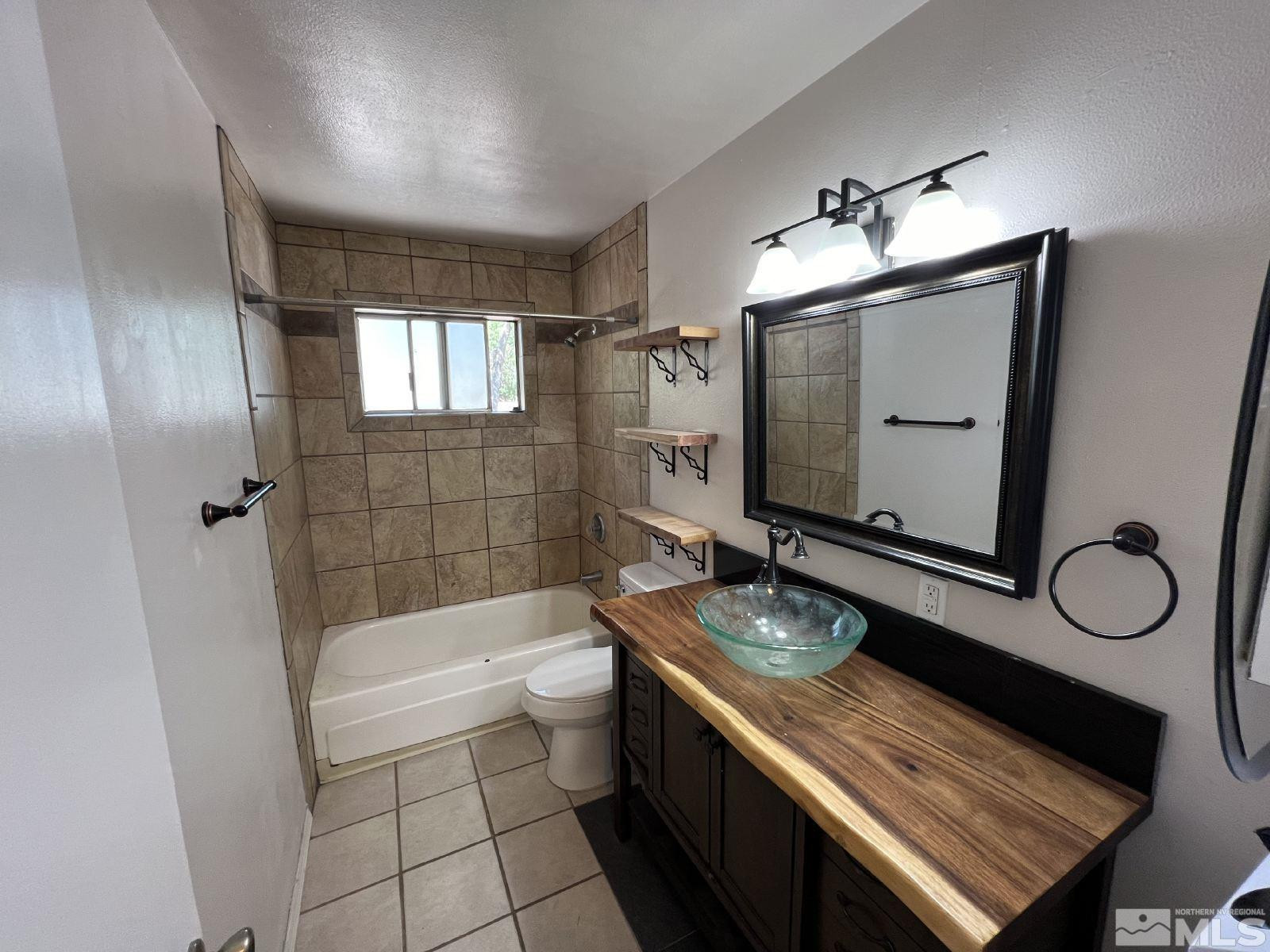 613 Pine Meadows Drive, Unit 4 Sparks, NV 89431 - Photo 8 of 14 a bathroom with a granite countertop toilet a sink and bathtub