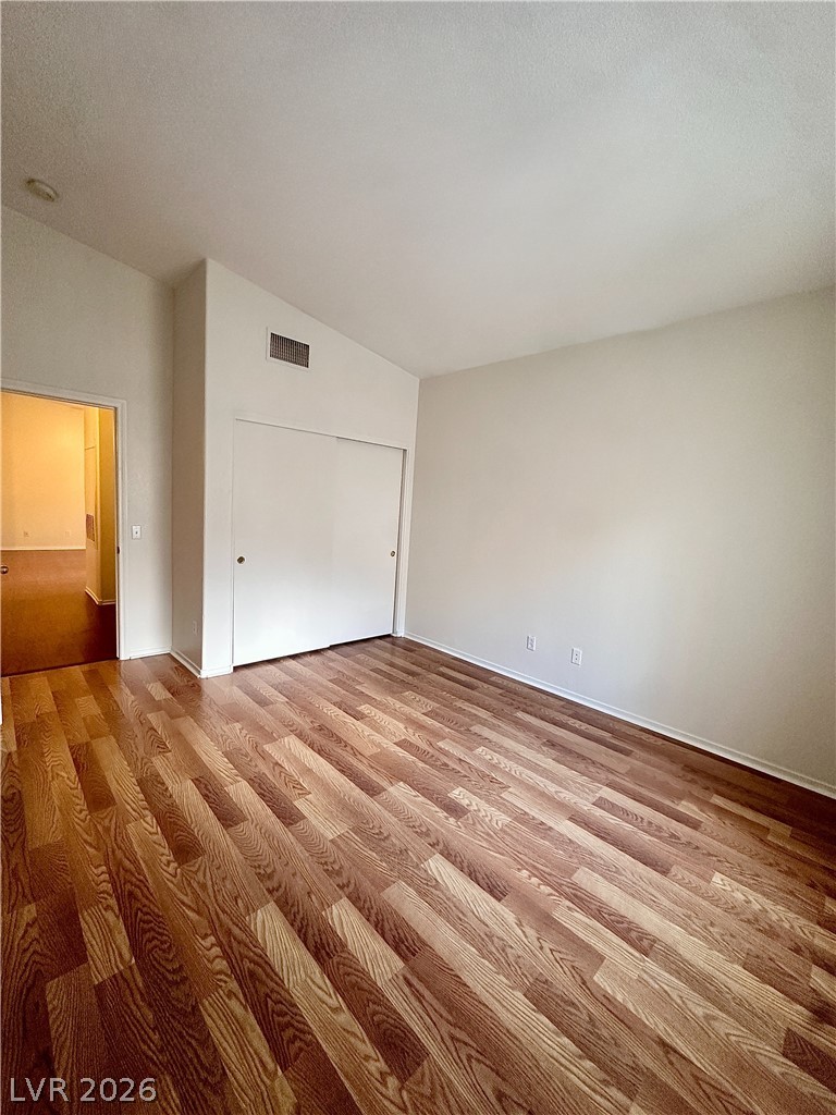 2053 Turquoise Ridge Street, Unit 202 Las Vegas, NV 89117 - Photo 7 of 18 Gleaming hardwood floors and a vaulted ceiling elevate this versatile bedroom.