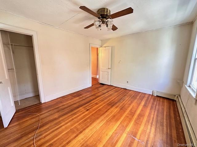 55 Woodhull Landing Road Sound Beach, NY 11789 - Photo 17 of 38 an empty room with wooden floor and a ceiling fan
