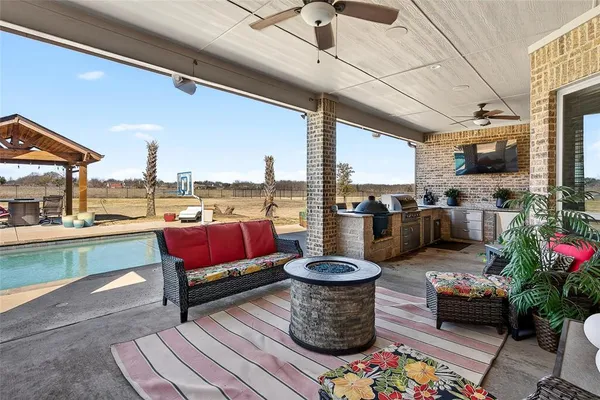 a kitchen with stainless steel appliances granite countertop a stove top oven a sink dishwasher a dining table and chairs with wooden floor