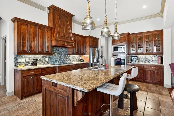 a kitchen with granite countertop a table chairs and wooden cabinets
