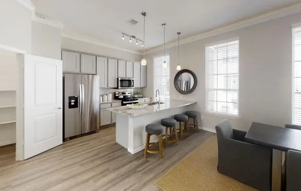 a living room with stainless steel appliances granite countertop furniture a fireplace a flat screen tv and a window