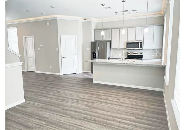 a view of kitchen with wooden floor and electronic appliances