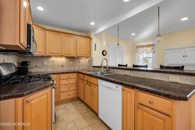 a kitchen with granite countertop a sink stainless steel appliances and cabinets