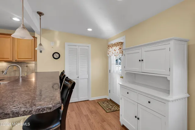 a kitchen with granite countertop white cabinets and wooden floor