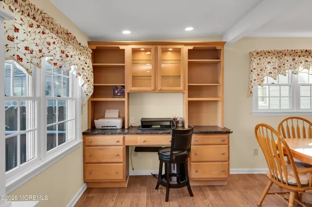 a view of a workspace with furniture and a window