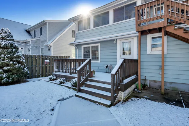 a view of wooden house with a small yard and wooden fence